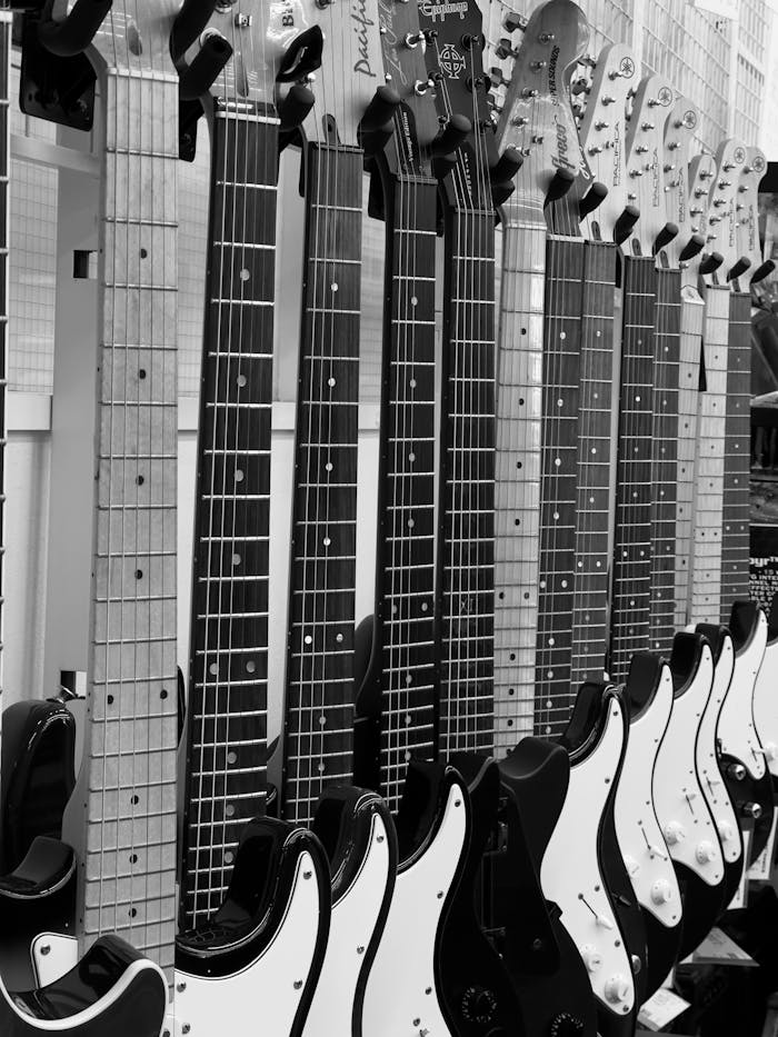 services-03 A striking black and white image of electric guitars neatly arranged in a store.