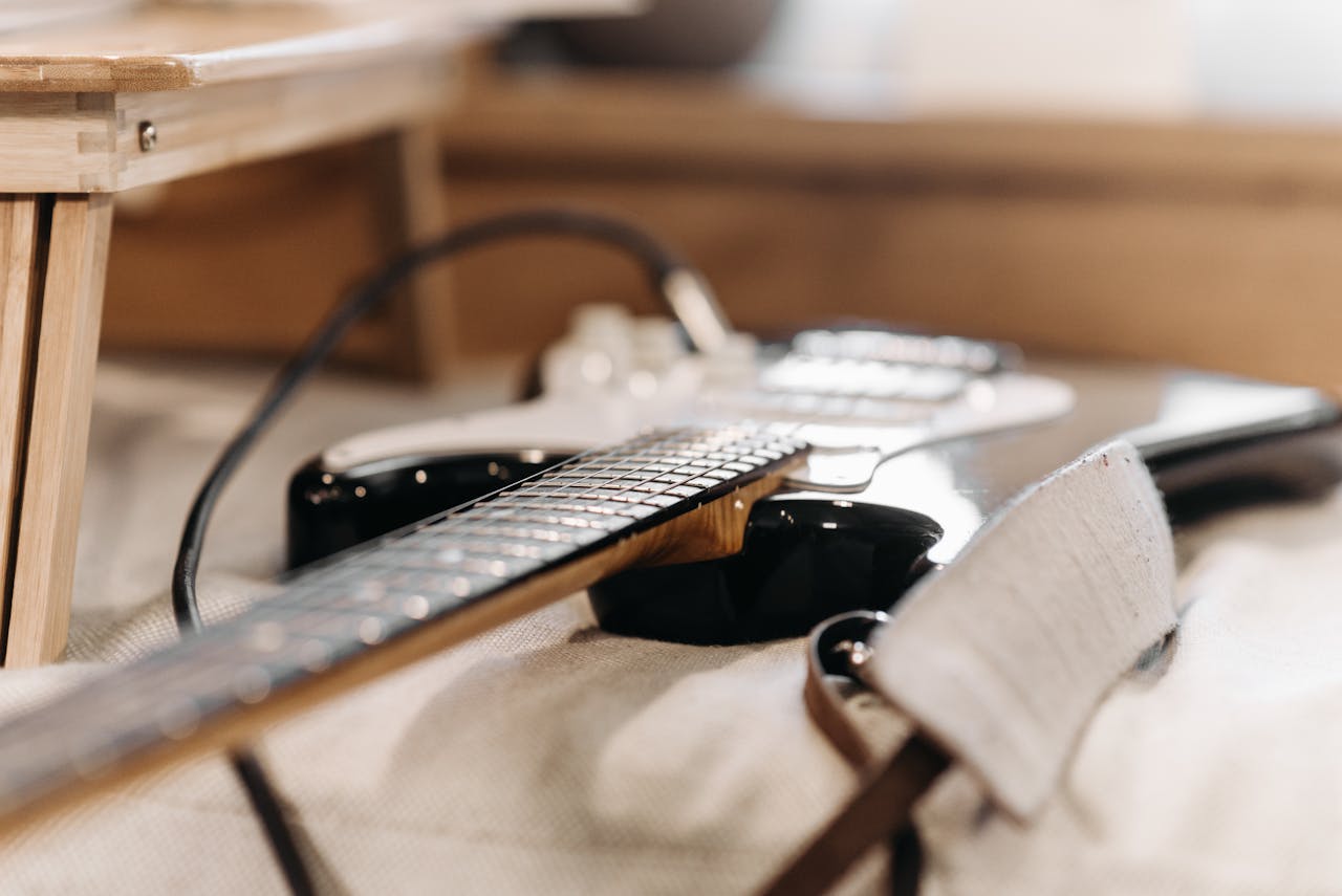 A close-up view of an electric guitar laid on soft fabric, highlighting the intricate design details.